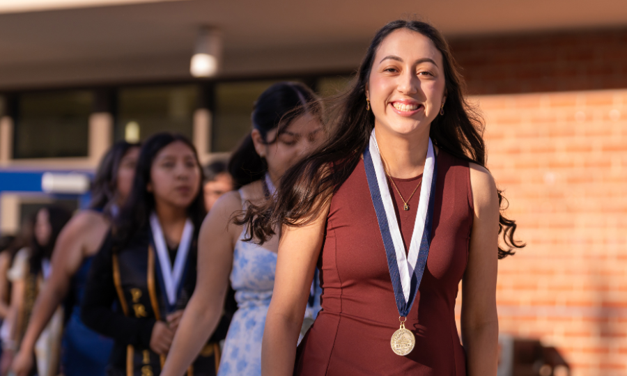 A student poses with their transfer medal at the Transfer Celebration.